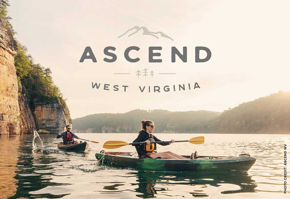 Two people kayaking on water in front of mountains and text that says "Ascend West Virginia"