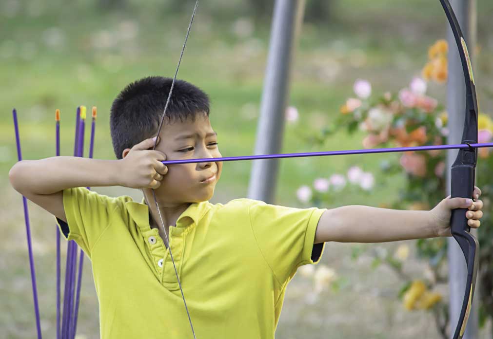 Child holding and aiming a bow and arrow