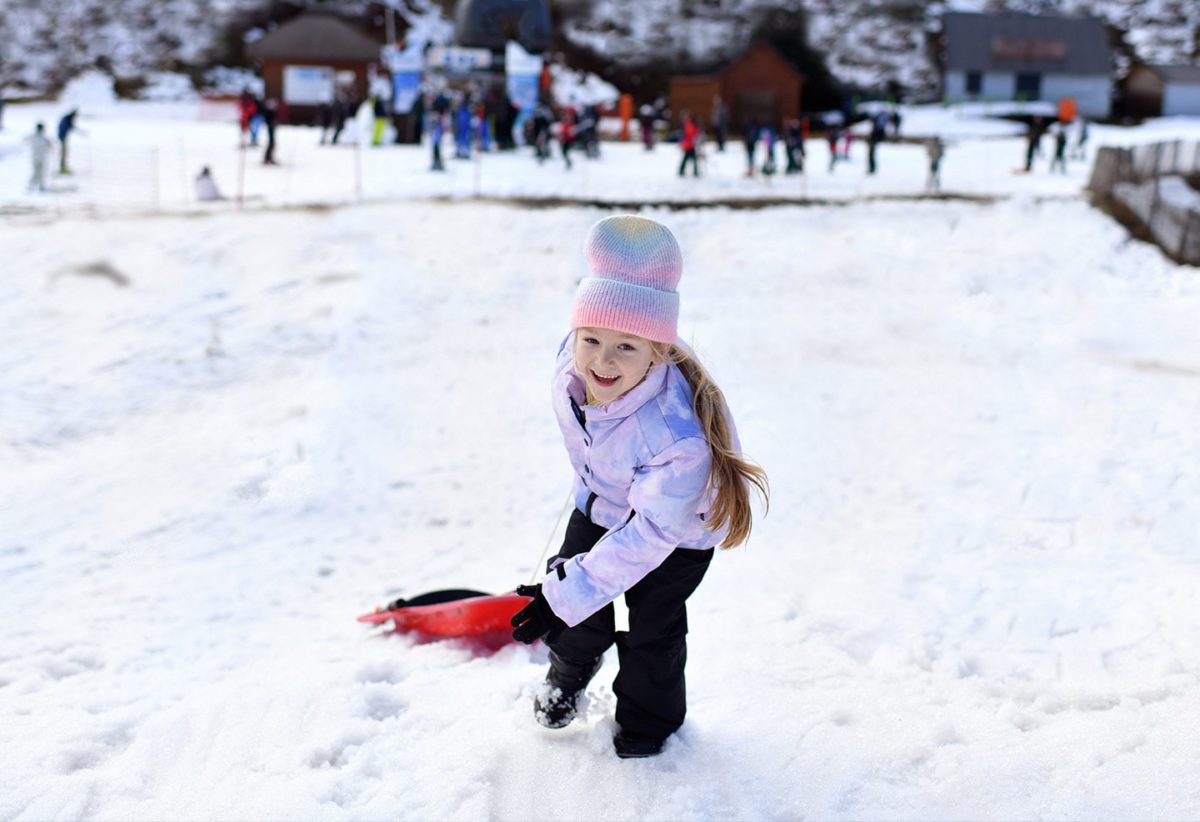 Little girl sledding in the snow