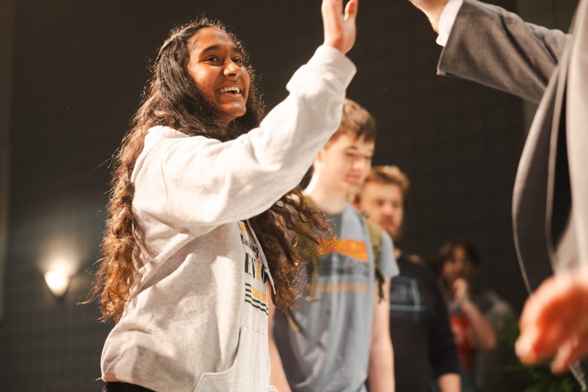 Female student beams as she high-fives Brad D. Smith at the Huntington High School Signing Day event.