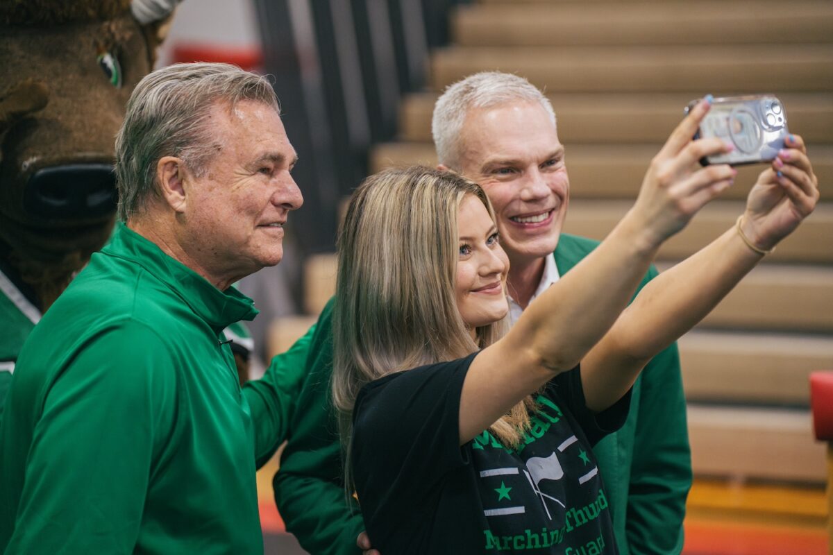 Student takes a selfie with Brad D. Smith and former men’s basketball coach Dan D’Antoni.