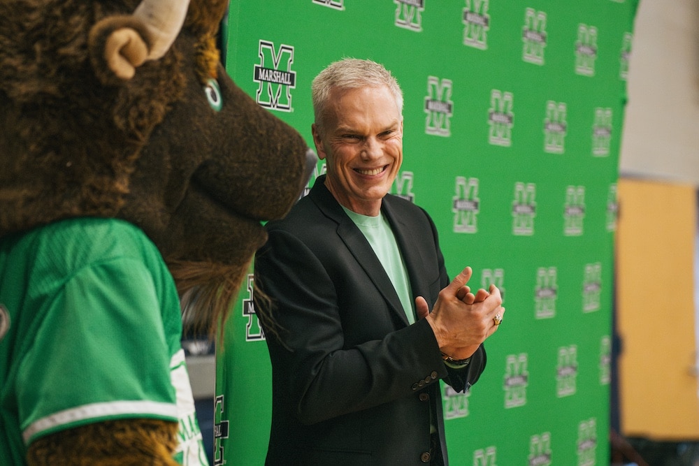 Brad D. Smith laughs with the Marshall University mascot, Marco the Bison.