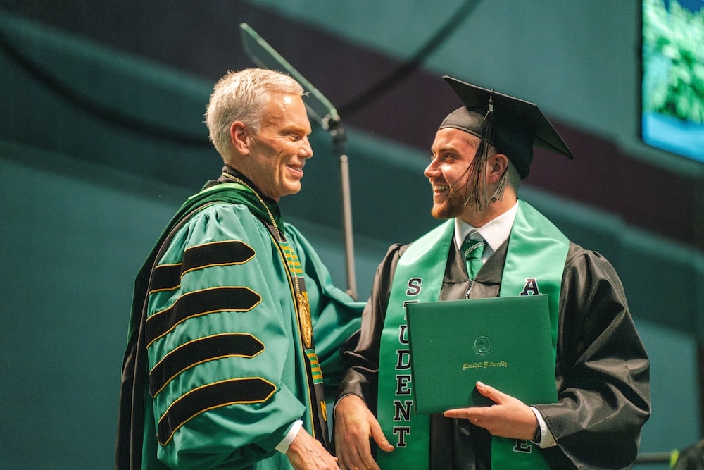 Marshall University president Brad D. Smith congratulates a graduating student at the 2025 spring commencement ceremony.